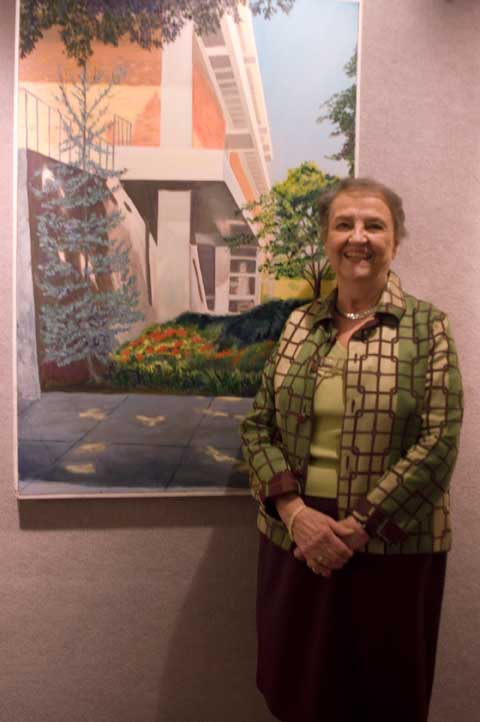 Artist Wright in front of panting of Anderson Hall