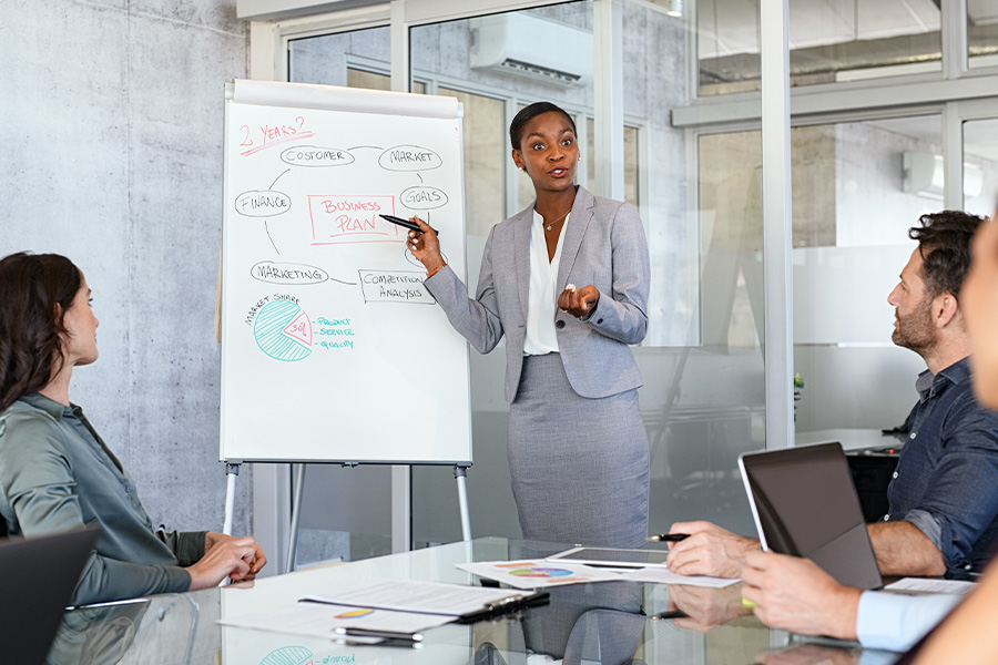 Woman in business suit presenting at a meeting