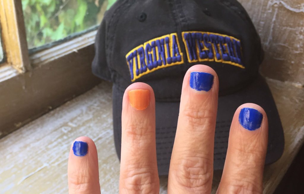 Stephanie's hand with blue and gold nails