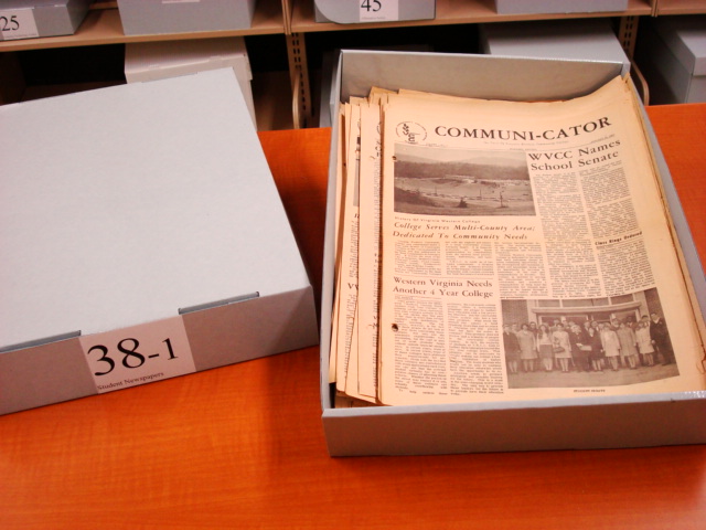 box of old Comuni-cator newsletters sitting on a table