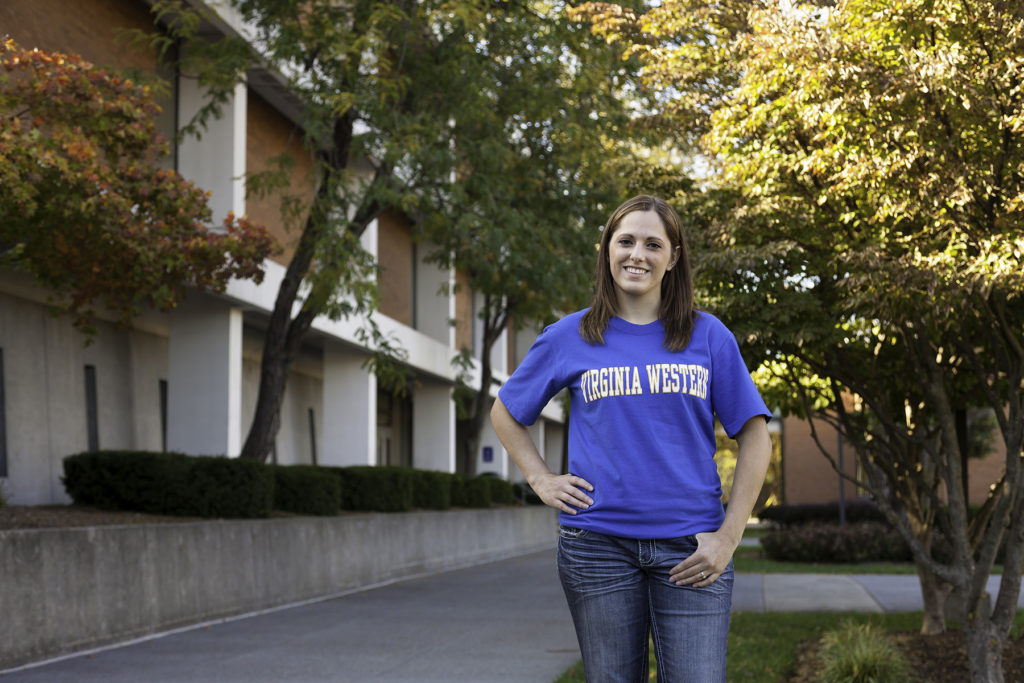 Student next to Anderson Hall in blue and gold Virginia Western t-shirt