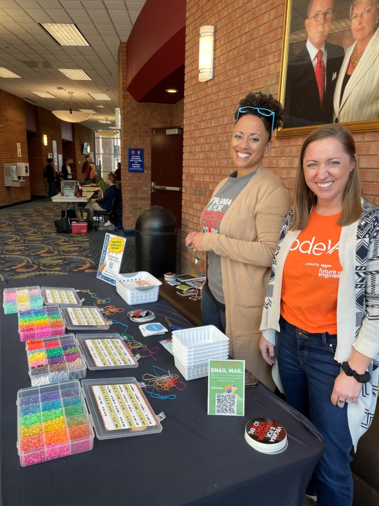 Kristen Franklin (left) and Megan Graybill with the nonprofit CodeVA organization connected with students at the Earth Summit with a hands-on activity, Binary Beads.