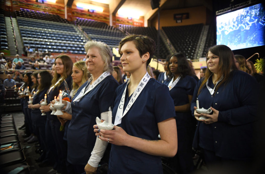 Graduates hold lamps at Virginia Western's AAS Nursing Program Pinning Ceremony on May 13, 2022, at Roanoke's Berglund Center.
