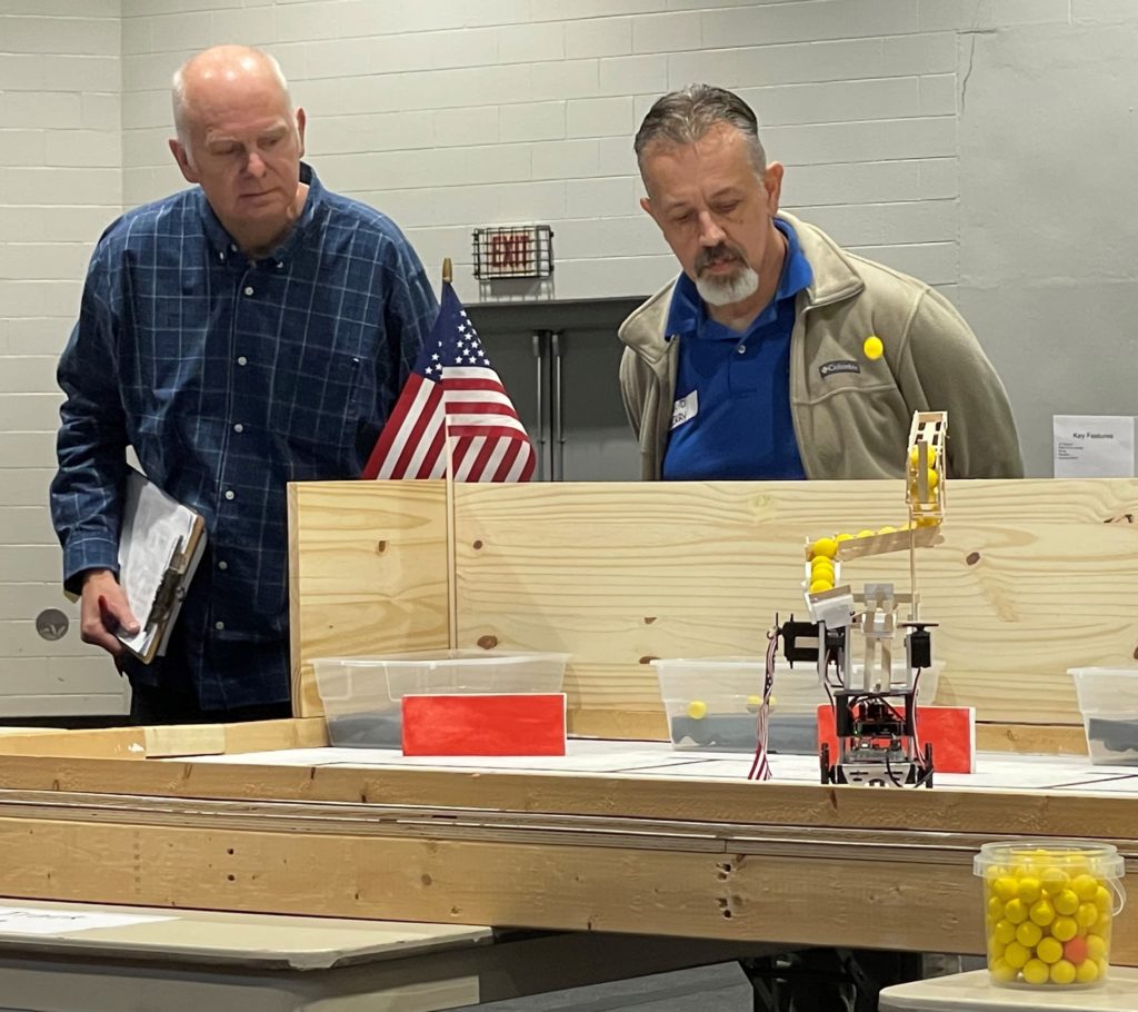 Virginia Western engineering faculty members George Studtmann (left) and David Berry watch the robot for the team Jonathan during one of the time trials on Saturday, Dec. 3. 