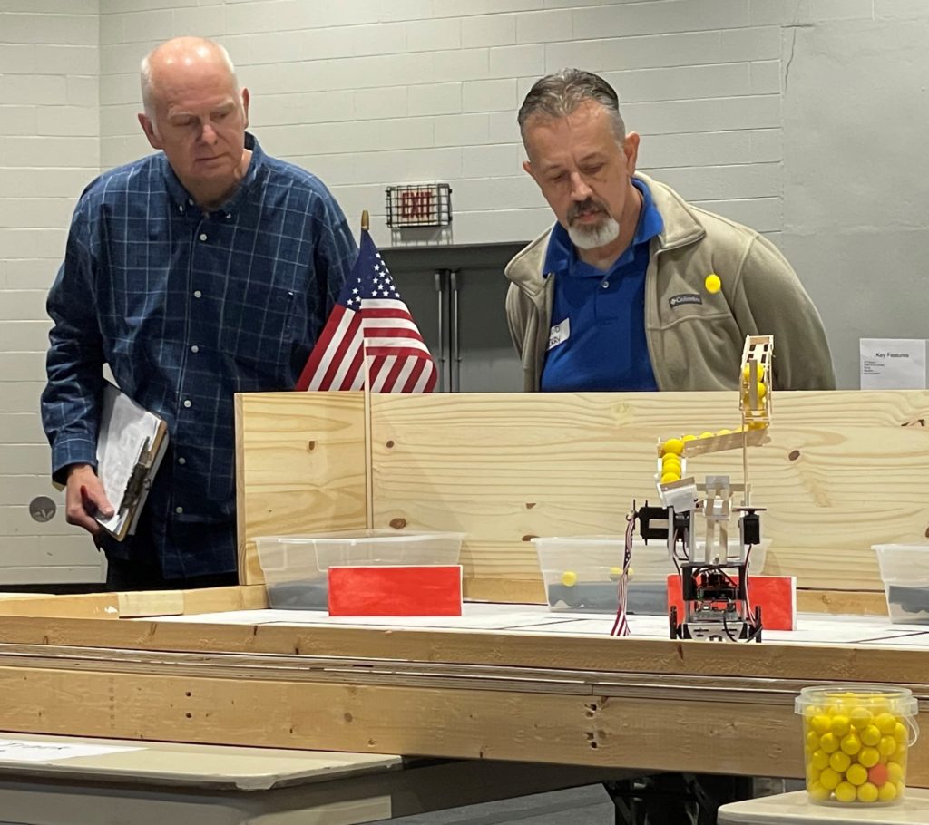 Virginia Western engineering faculty members George Studtmann (left) and David Berry watch the robot for the team Jonathan during one of the time trials on Saturday, Dec. 3.