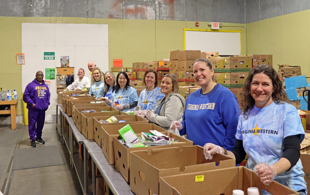 James Andrews (left) instructs Virginia Western volunteers in the morning shift at Feeding Southwest Virginia in Salem. Through the window, Joe Nguyen and Alexander Scott wait to move the sorted boxes. Visible in the pre-sort line (from left) are: James Zeisler, George Studtmann, Heather Harris, Tara Altorre, Carrie Halpin, Erin Leftwich, Andrea Martin, Jordan Tucker and Jennifer Kurtz. They cleaned the donations and sorted them by category.