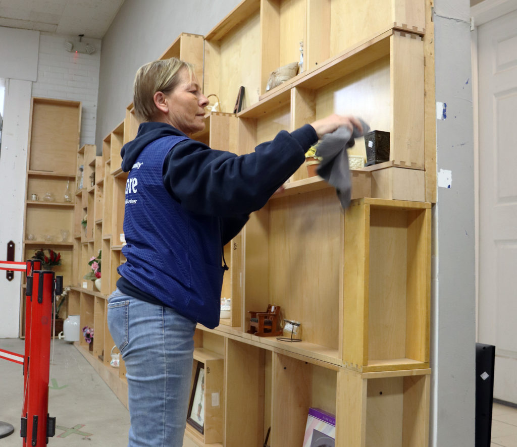 Sarah Chitwood dusts merchandise at the Habitat for Humanity ReStore.