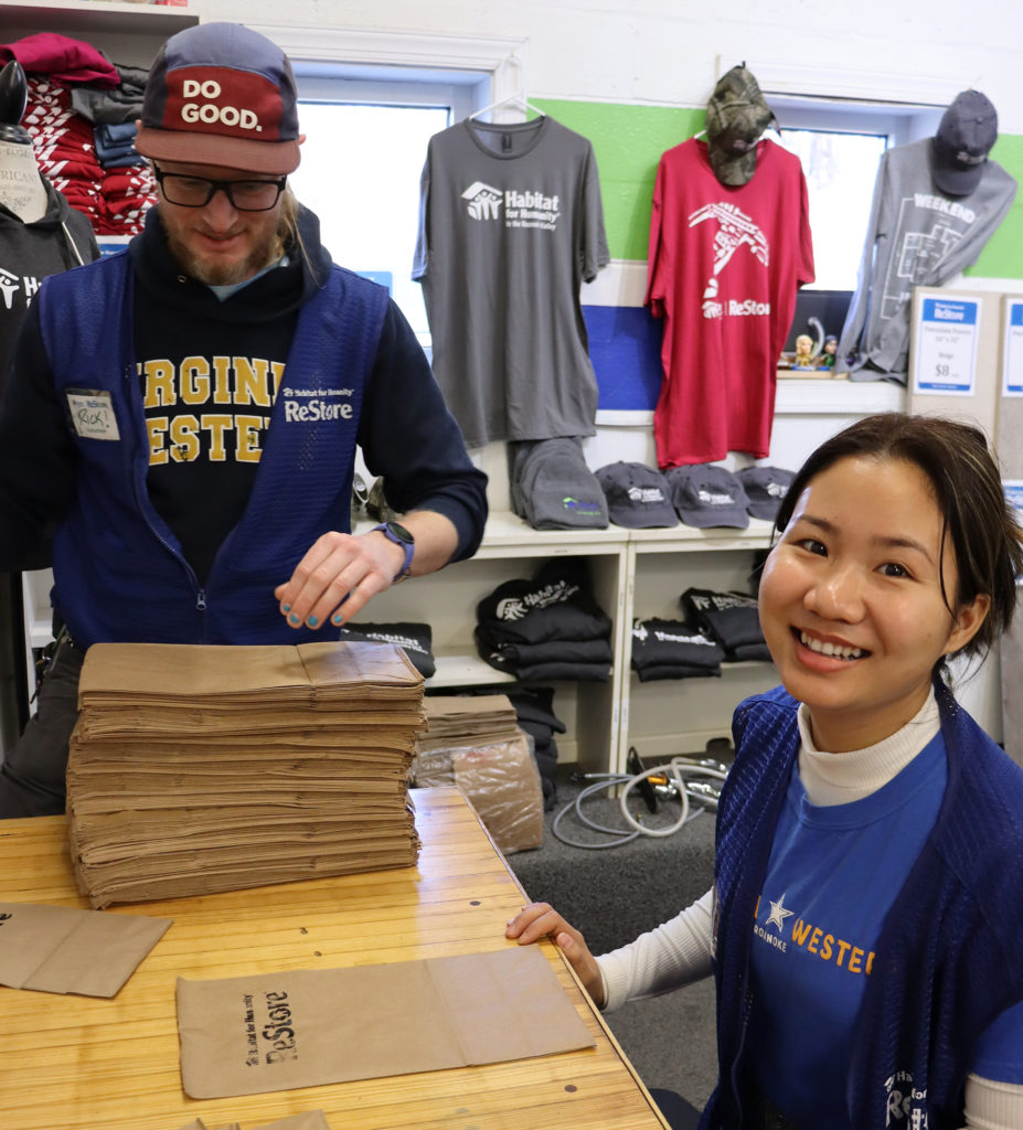Rick Henegar and Elitha Moe prep bags at the Habitat for Humanity ReStore's checkout counter.