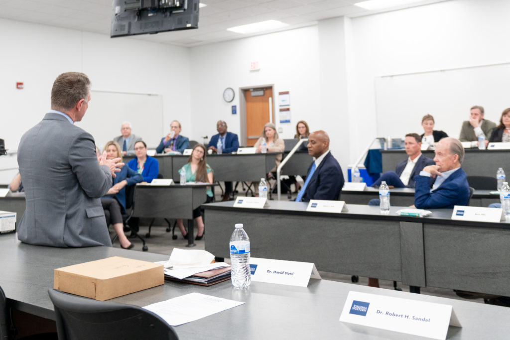 Dr. David Doré speaks with a group including business and industry leaders.