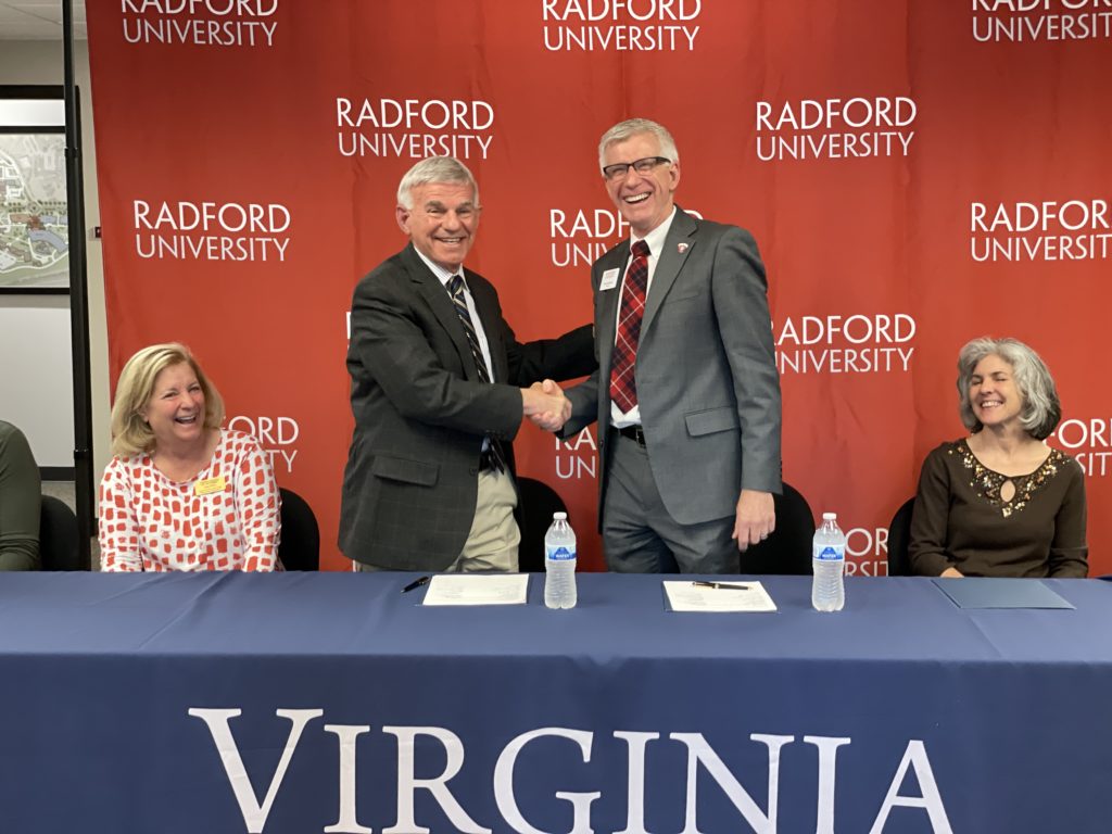 Dr. Robert Sandel (center left) and Dr. Bret Danilowicz (center right) celebrate signing the articulation agreement on Monday, May 1. Photo courtesy of Radford University.