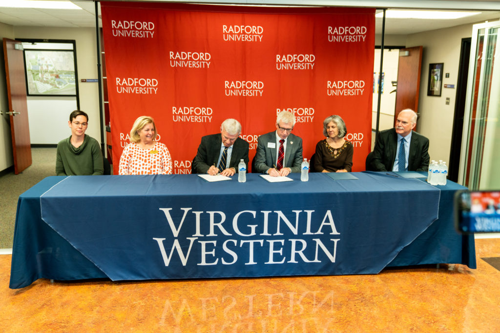 Virginia Western Community College and Radford University officials signed the articulation agreement on Monday, May 1. Seated from left are: Dr. Heather Lindberg, Virginia Western associate professor of biology; Virginia Western Dean of STEM Amy White; Dr. Robert Sandel, Virginia Western president; Dr. Bret Danilowicz, Radford University president; Dr. Christine Small, professor and interim chair of Radford's department of biology; Dr. Steven Bachrach, dean of Radford's Artis College of Science and Technology. Photo courtesy of Radford University.