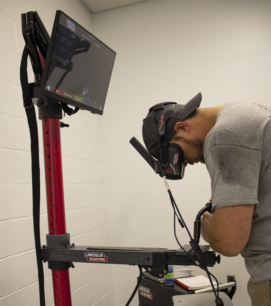 Josh Waldron uses a virtual reality simulator to practice MIG welding during his coursework for Virginia Western's fast-track Career Studies Certificate in welding.