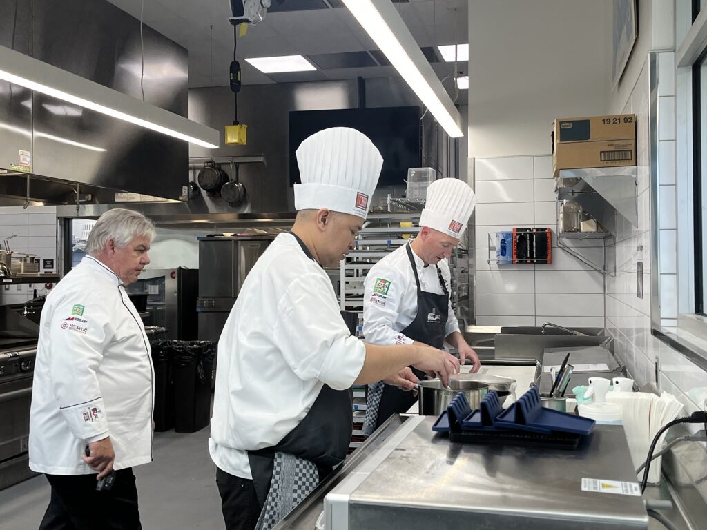 Team manager Chef Kevin Storm (left) inspects the work of Chef Troman Felizmenio (center) and Chef Ted Polfelt on Monday, Nov. 6.