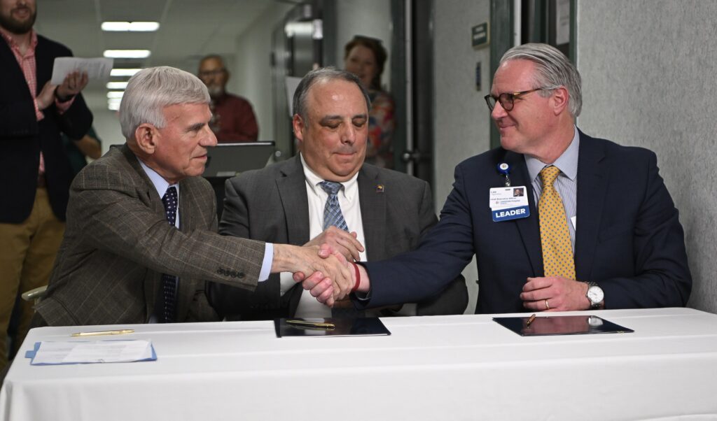 VWCC President Dr. Robert Sandel (left), MGCC President Dr. John Rainone (middle) and Lee Higginbotham, CEO of LewisGale Hospital Alleghany shake hands after signing the agreement.