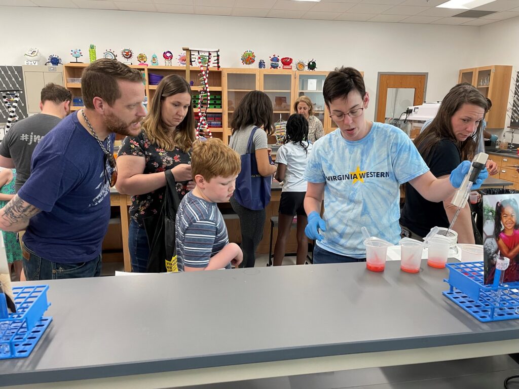 Kids extract DNA from strawberries in the Biotechnology Lab at STEM Day in 2023.