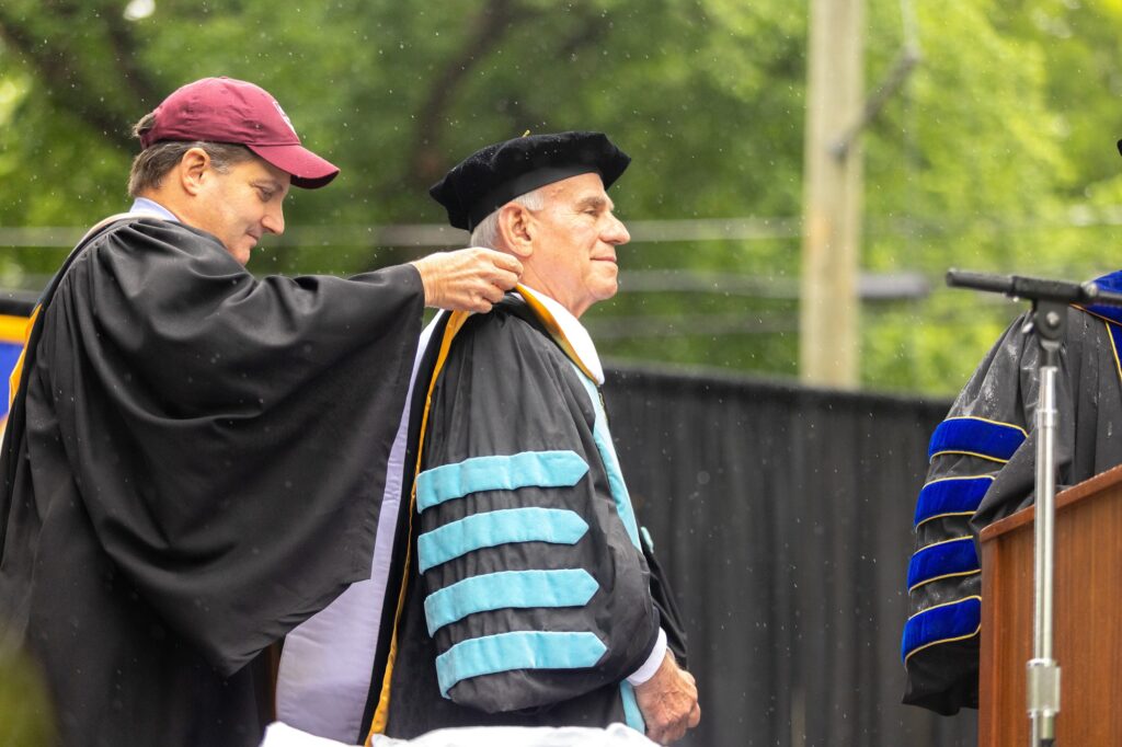Malon Courts, chair of Roanoke College Board of Trustees, places the hood on Dr. Robert Sandel. Courtesy of Roanoke College.
