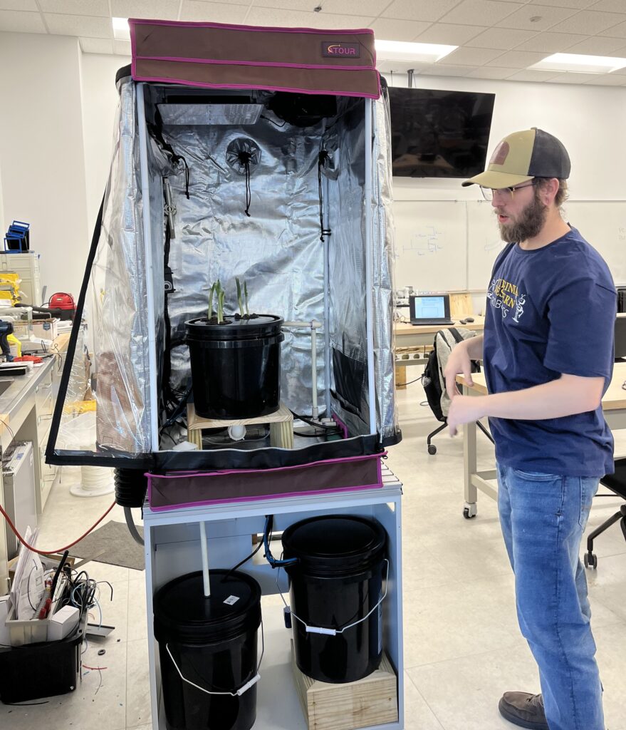 Timothy Boyd shows the fully industrial-controlled hydroponics chamber he and Daniel Moran built.