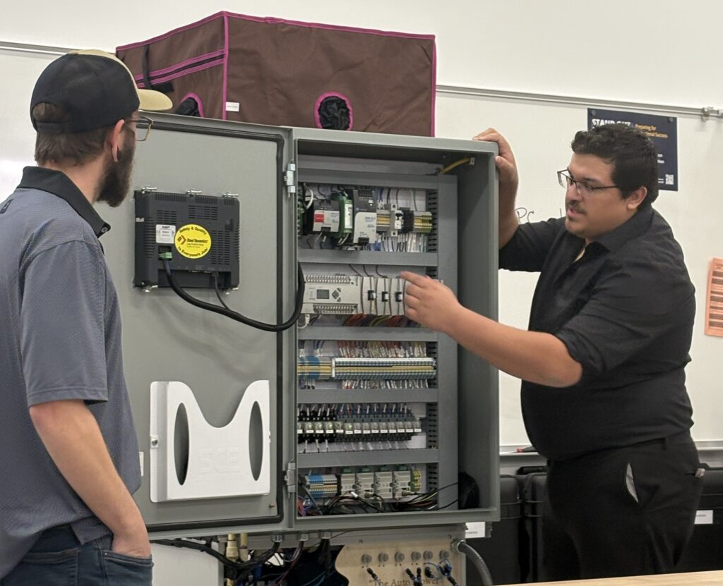 Timothy Boyd (left) and Daniel Moran demonstrate the hydroponics chamber they constructed.