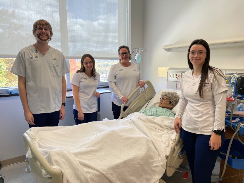 Virginia Western nursing students (from left) Cody Shelton, Teresa Jamison, Kim Young and Danielle Ledbetter are members of the Earn to Learn cohort this year. Here they are seen with a high-fidelity simulation mannequin used in Virginia Western's Associate of Applied Science Nursing Program, a pre-licensure RN program.