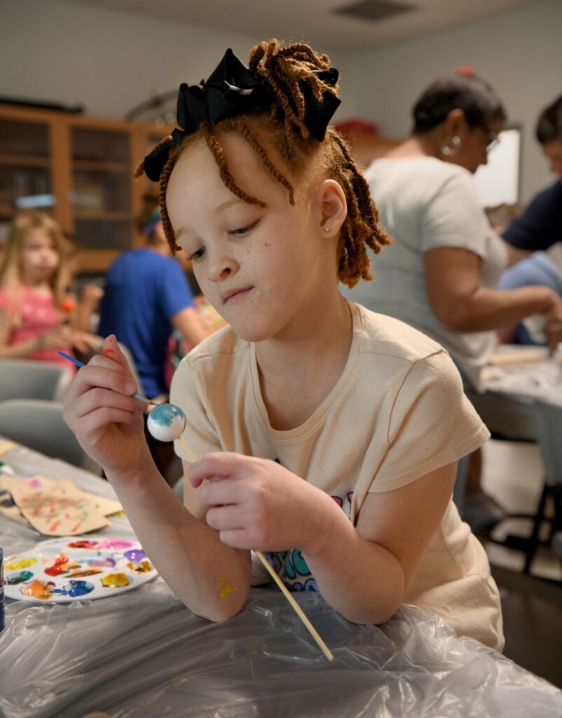 Young learners paint their own planets and learn about the phases of the moon at the Astronomy exhibit.