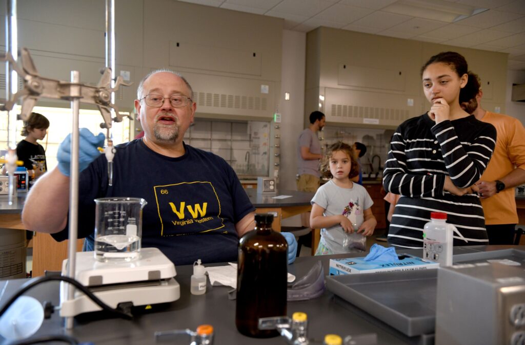 STEM Professor Mark Dudley leads students through demonstrations of chemistry in action, showing how bases and acids react to one another.