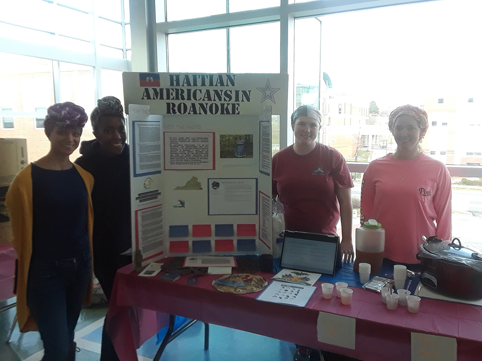 Haitian culture is represented at a table at the Nursing Cultural Fair. Students are seen here with information about the Haitian culture.