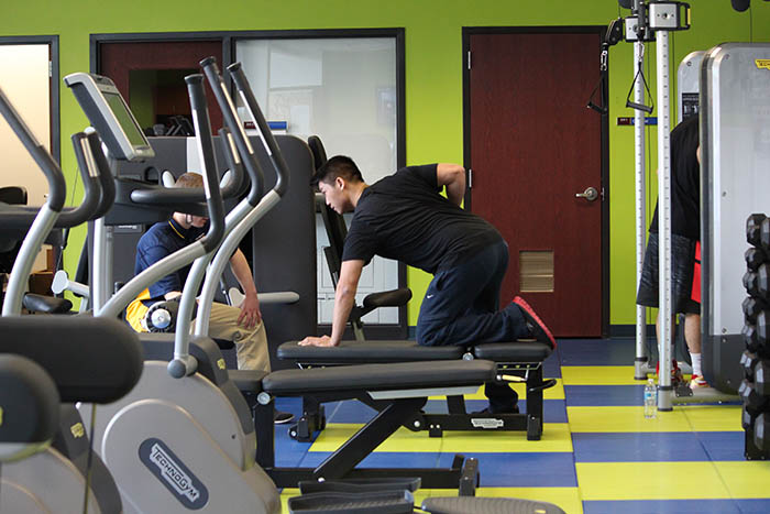 A student works out using dumbbells in Virginia Western's fitness center.
