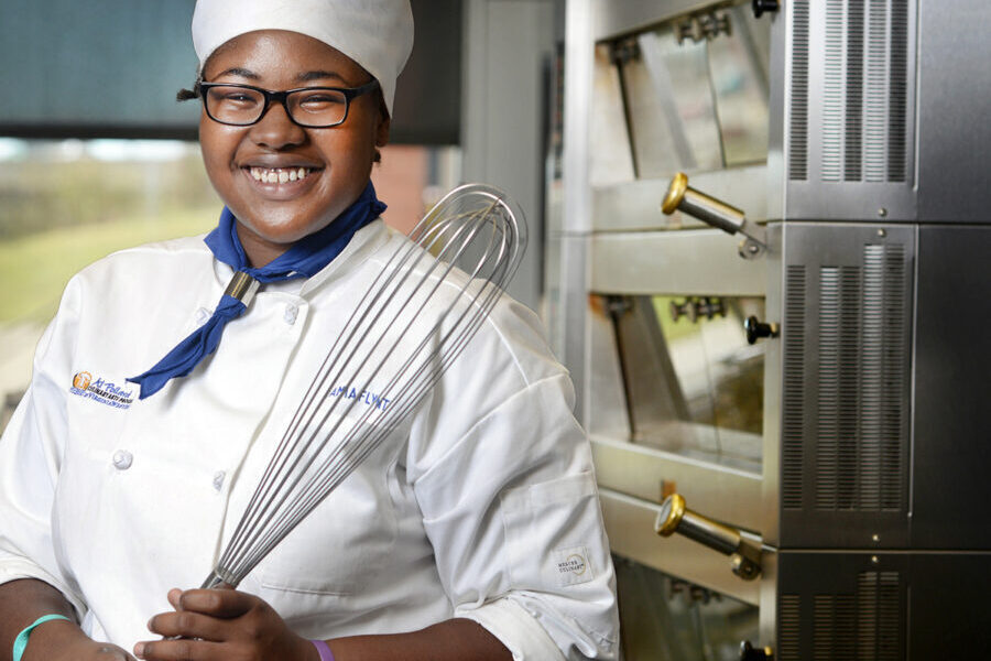culinary arts student holding a whisk