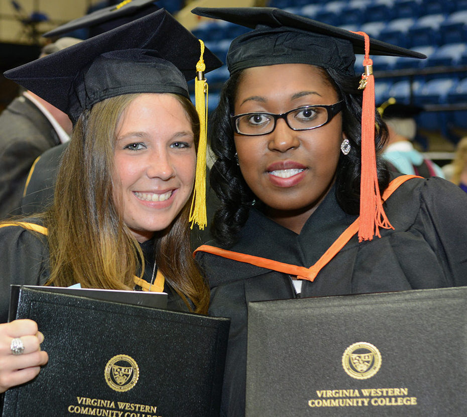 Two female graduates holding their diplomas