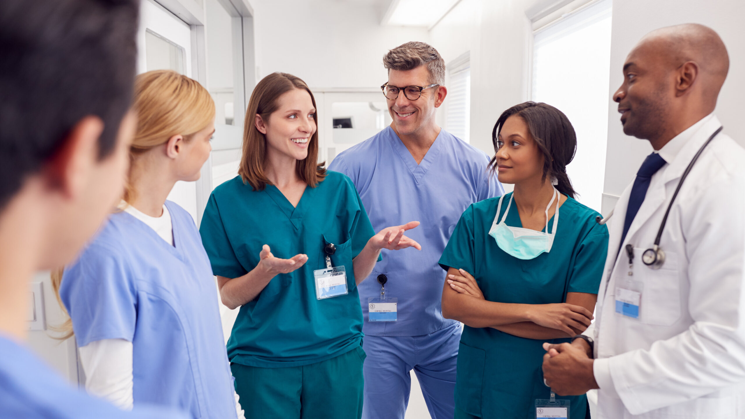 Multi-Cultural Medical Team Having Meeting In Hospital Corridor